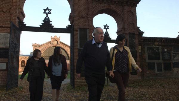 Manny Drukier (C) with his wife, Freda (L), granddaughter Leah (2nd L), and daughter Cindy at the Lodz Jewish Cemetery in Poland. (Courtesy of Long Trek Home Productions)