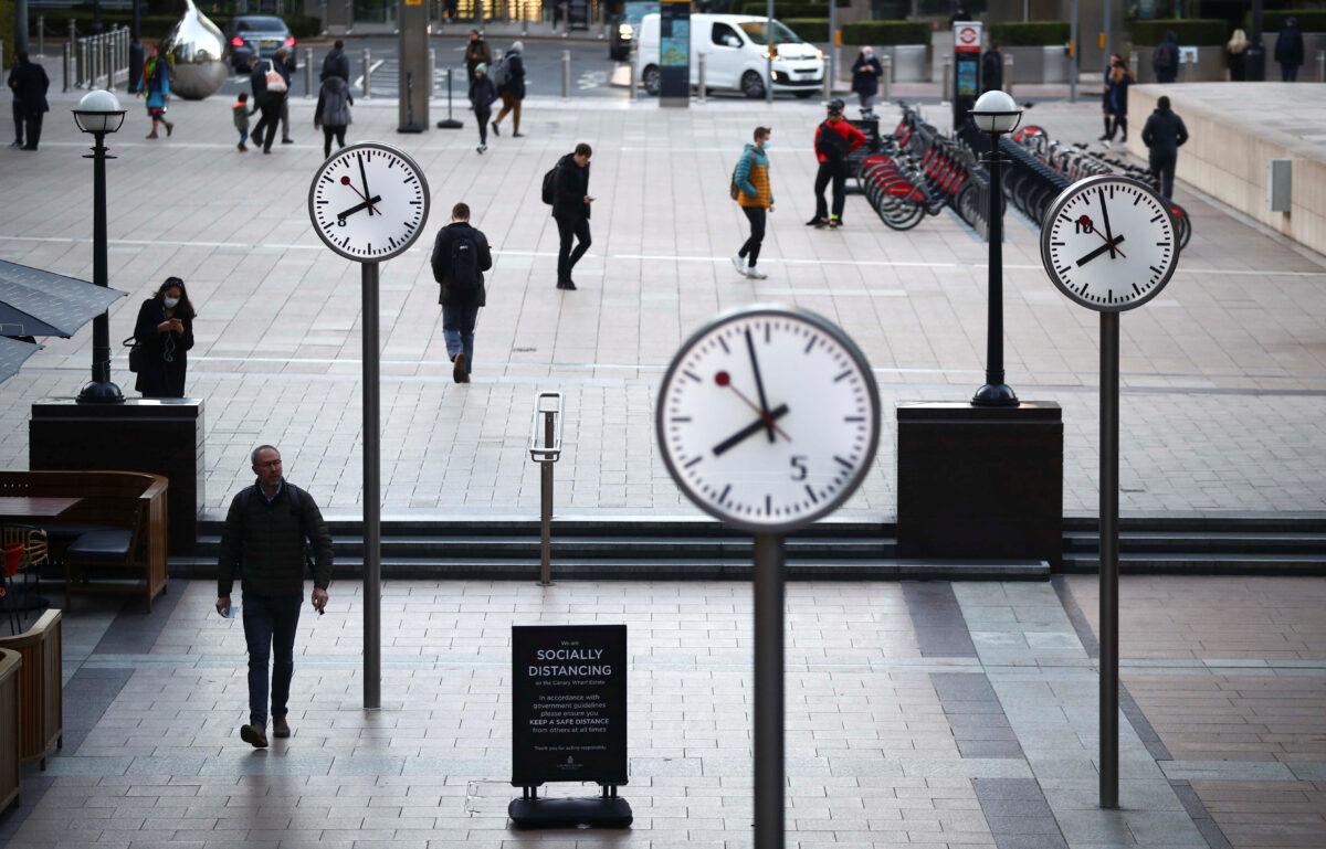 File photo shows people walking during the morning rush hour in the Canary Wharf amid the outbreak of the CCP virus in London, on Oct. 15, 2020. (Hannah McKay/Reuters)