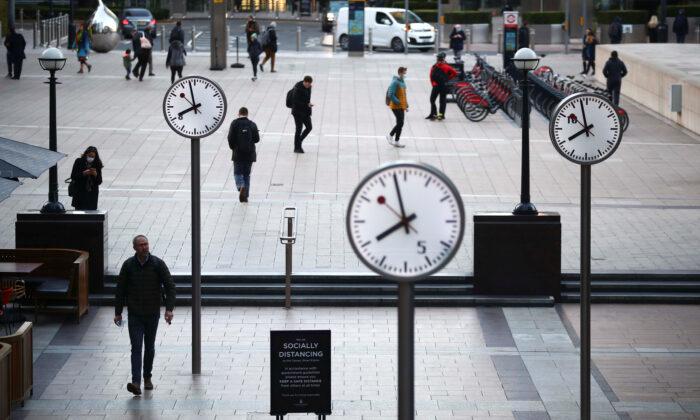 People walking during the morning rush hour in the Canary Wharf amid the outbreak of the CCP virus in London on Oct. 15, 2020. (Hannah McKay/Reuters)
