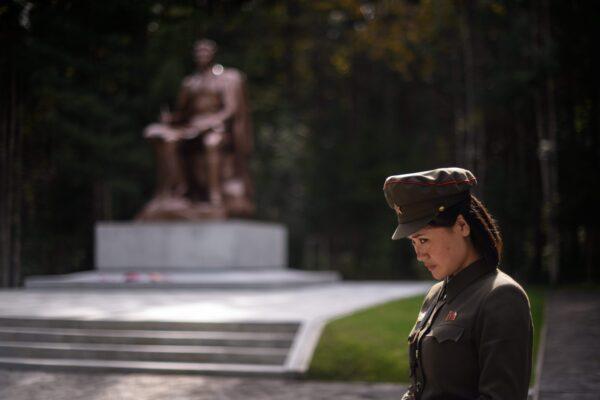 A guide is standing before a statue of late North Korean leader Kim Il Sung at the barracks of a secret camp near Samjiyon in North Korea on Sept. 12, 2019. (ED JONES/AFP via Getty Images)