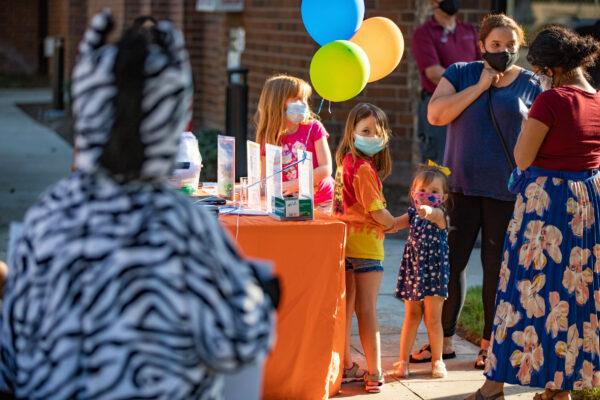 Children are fascinated by a person wearing a zebra costume at an event launching Orange County's WiFi on Wheels program in Westminster, Calif., on Oct. 20, 2020. (John Fredricks/The Epoch Times)