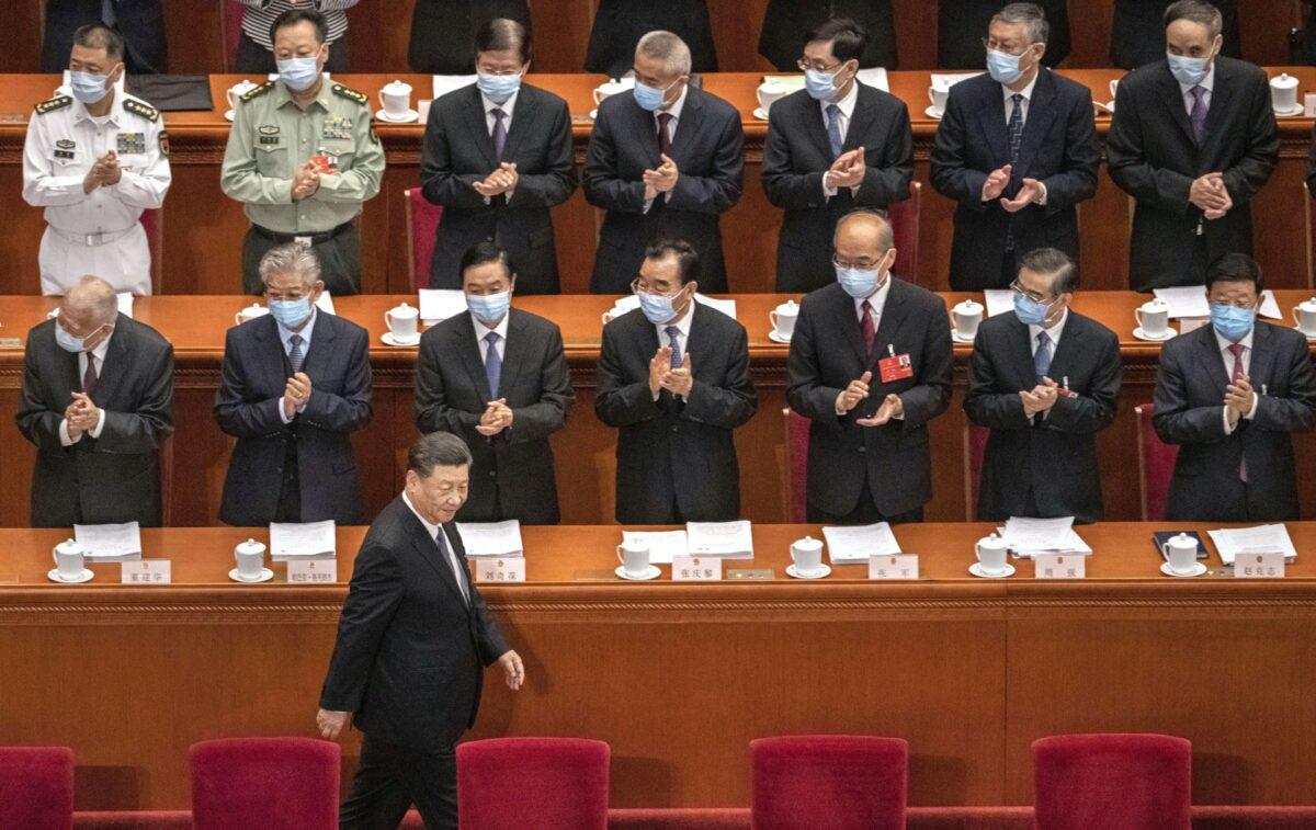 Chinese leader Xi Jinping is applauded by delegates wearing protective masks as he arrives at the opening of the National People's Congress at the Great Hall of the People in Beijing, on May 22, 2020. (Kevin Frayer/Getty Images)