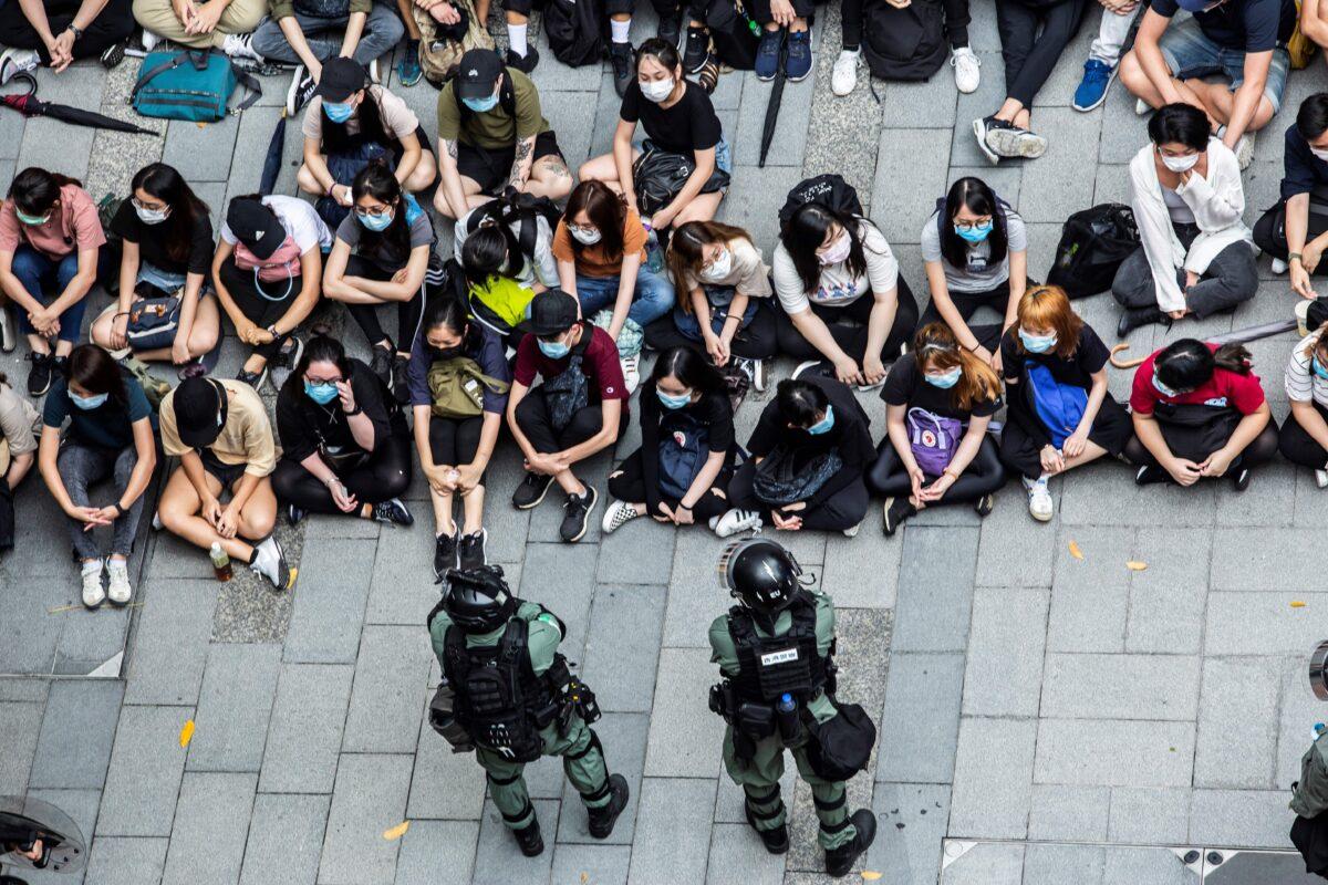 Riot police detain a group of people during a protest in the Causeway Bay district of Hong Kong on May 27, 2020, as the city's legislature debates over a law that bans insulting China's national anthem. - Hong Kong police placed a dragnet around the financial hub's legislature on May 27 and fired pepper-ball rounds in the commercial district as they tried to stamp out protests against a bill banning insults to China's national anthem. (Photo by ISAAC LAWRENCE / AFP) (Photo by ISAAC LAWRENCE/AFP via Getty Images)