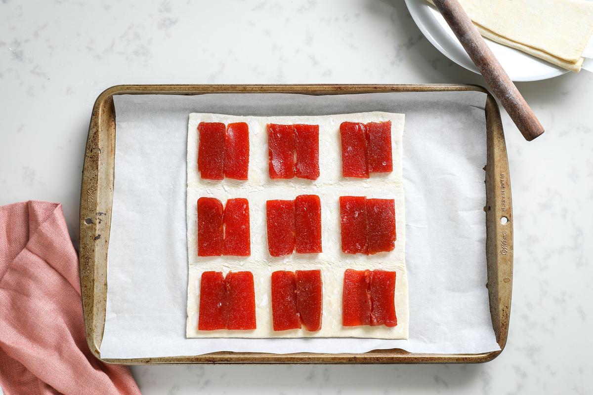 Distribute slices of guava paste on a sheet of puff pastry. (Samira Bouaou/The Epoch Times)