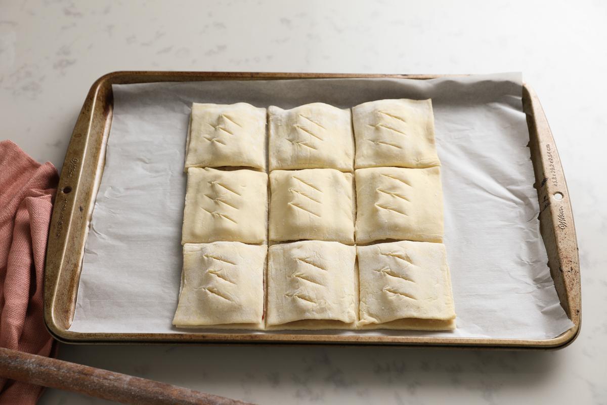 Cover with the second sheet of puff pastry, cut into squares, and score the tops. (Samira Bouaou/The Epoch Times)