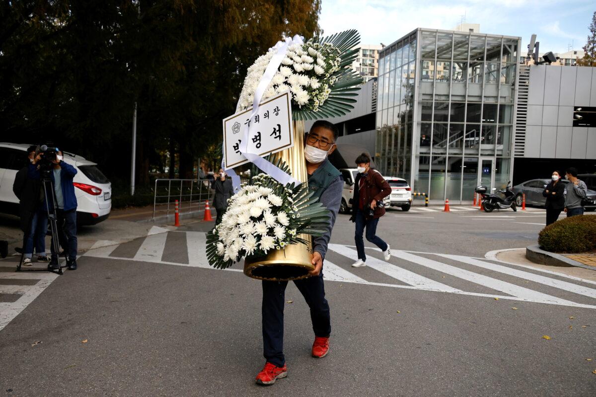 A wreath of flowers from South Korea's National Assembly Speaker Park Byeong-seug is carried by a worker outside a funeral parlor where the funeral of Lee Kun-hee, leader of Samsung Group, will take place, in Seoul, South Korea, on Oct. 25, 2020. (Kim Hong-Ji/Reuters)