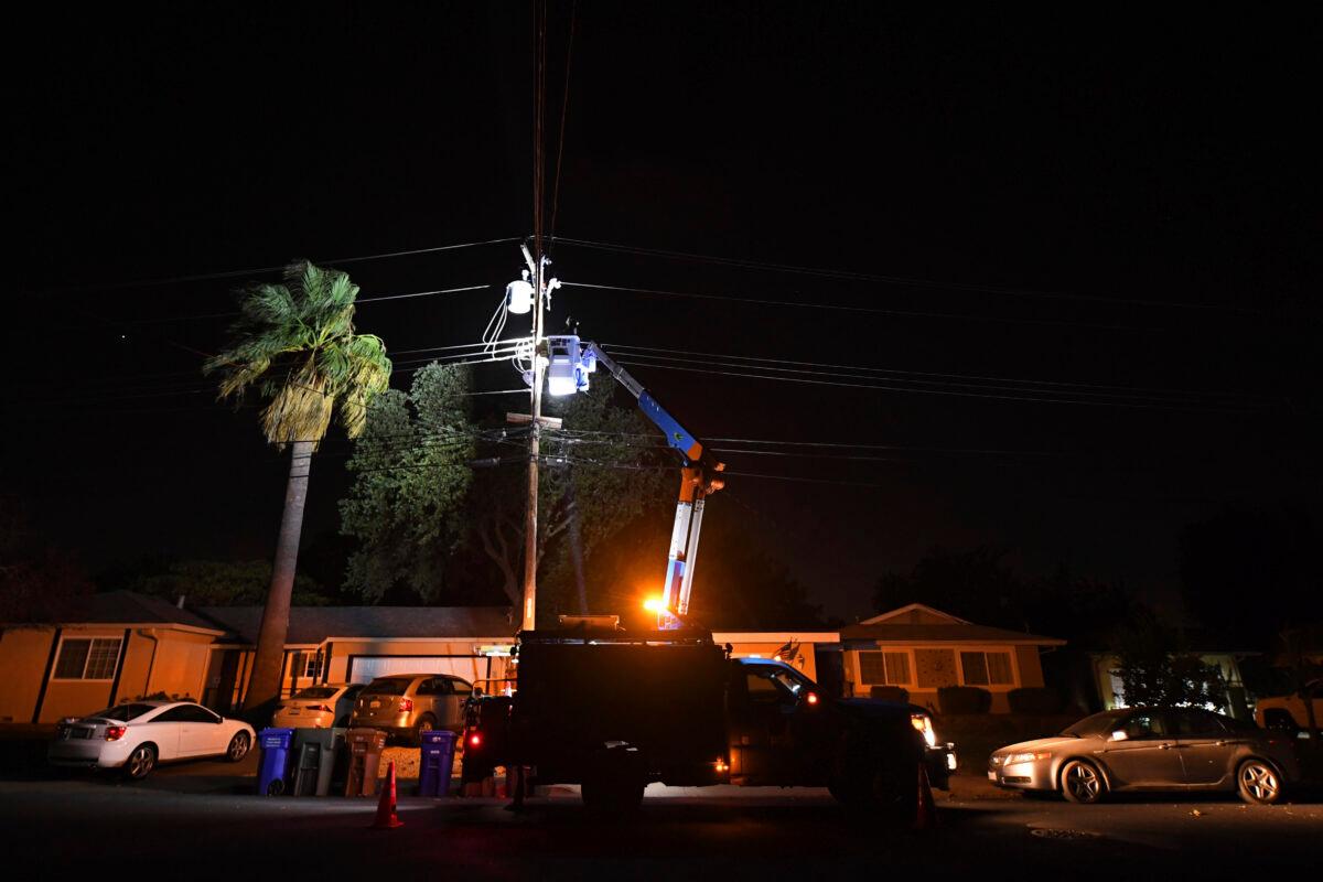 A PG&E lineman works on repairing electrical wires that were touching due to high winds on Manzanita Court in Concord, Calif., on Oct. 25, 2020. (Jose Carlos Fajardo/Bay Area News Group via AP)