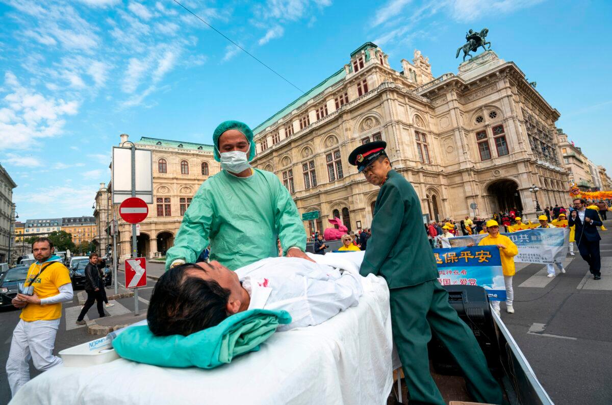 Falun Gong practitioners stage a demonstration of organ harvesting of imprisoned practitioners in China during a protest against the importing of human organs from China to Austria, in Vienna, Austria, on Oct. 1, 2018. (Joe Klamar/AFP via Getty Images)