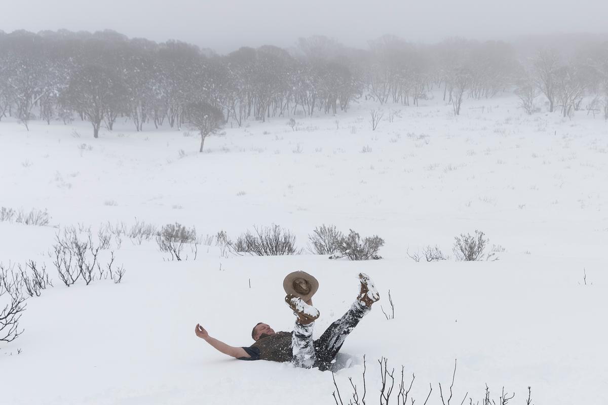 Last year Australia also experienced a polar event that caused widespread snowfall. A tourist buries himself in the snow on August 23, 2020 near the small Snowy Mountains town of Adaminaby, Australia.  (Photo by Brook Mitchell/Getty Images)