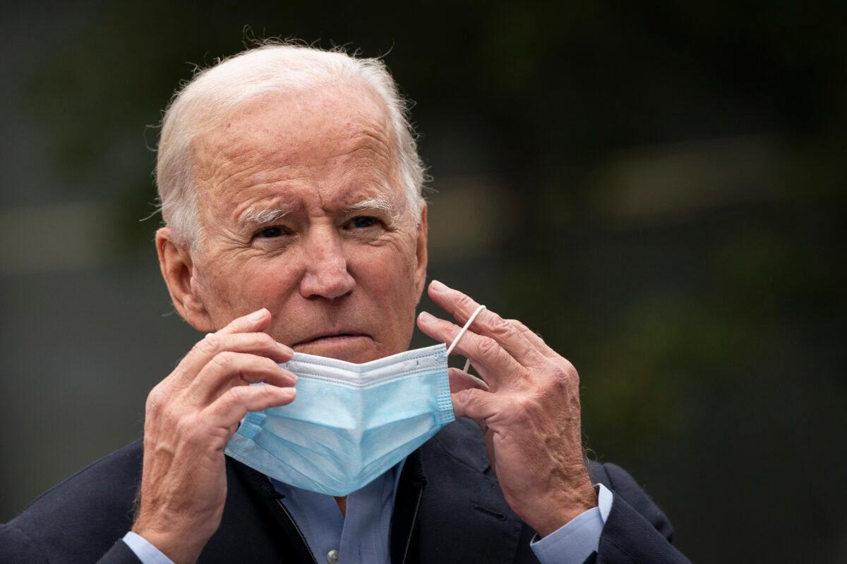 Democratic presidential nominee Joe Biden puts on a mask while speaking to reporters in Chester, Penn., on Oct. 26, 2020. (Drew Angerer/Getty Images)