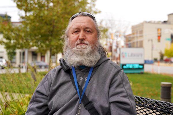 Scott Hamilton sits on a bench in from of the Vigo County Public Library in downtown Terre Haute, Ind., on Oct. 20, 2020. (Cara Ding/The Epoch Times)