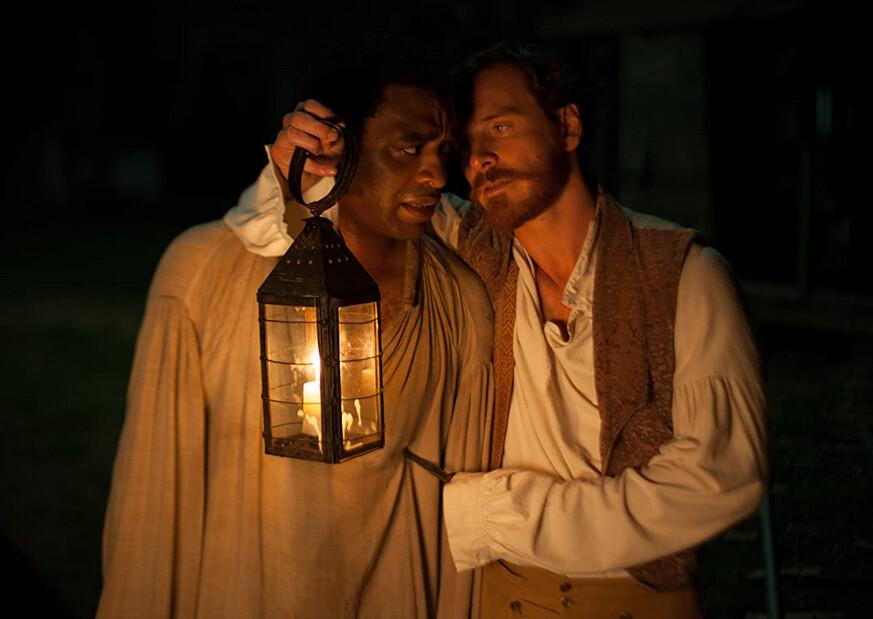 Solomon Northup (Chiwetel Ejiofor, L) is threatened at knife-point by his new master Edwin Epps (Michael Fassbender) in "12 Years a Slave." (Twentieth Century Fox)