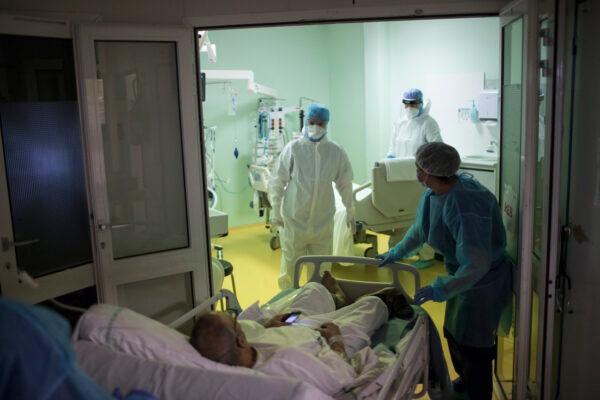 A medical crew receive a COVID-19 patient into the intensive care unit at the Joseph Imbert Hospital Center in Arles, southern France, on Oct. 28, 2020. (AP Photo/Daniel Cole)