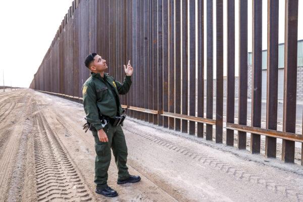 Border Patrol agent Jose Girabay stands next to part of the 30-foot high new fence on the U.S–Mexico border east of San Luis in Yuma, Ariz., on Nov. 27, 2019. (Charlotte Cuthbertson/The Epoch Times)