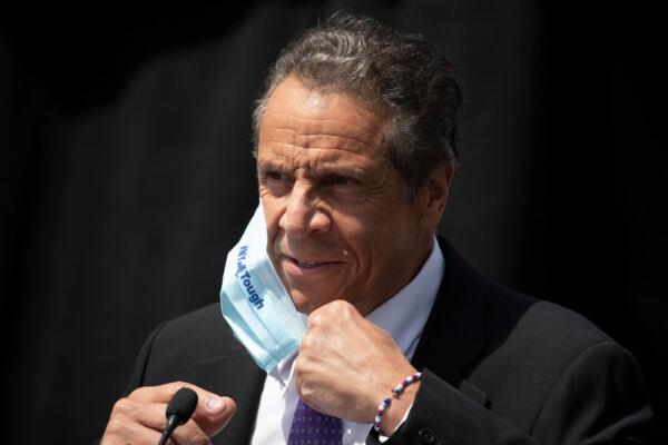 New York Gov. Andrew Cuomo removes a mask as he holds a news conference in Tarrytown, N.Y. (AP Photo/Mark Lennihan, File)