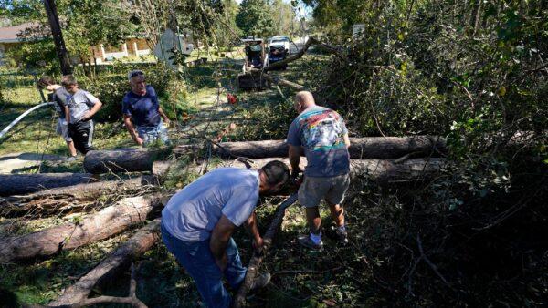 Residents use chain saws to clear fallen trees in the aftermath of Hurricane Zeta in Waveland, Miss., on Oct. 29, 2020. (Gerald Herbert/AP Photo)
