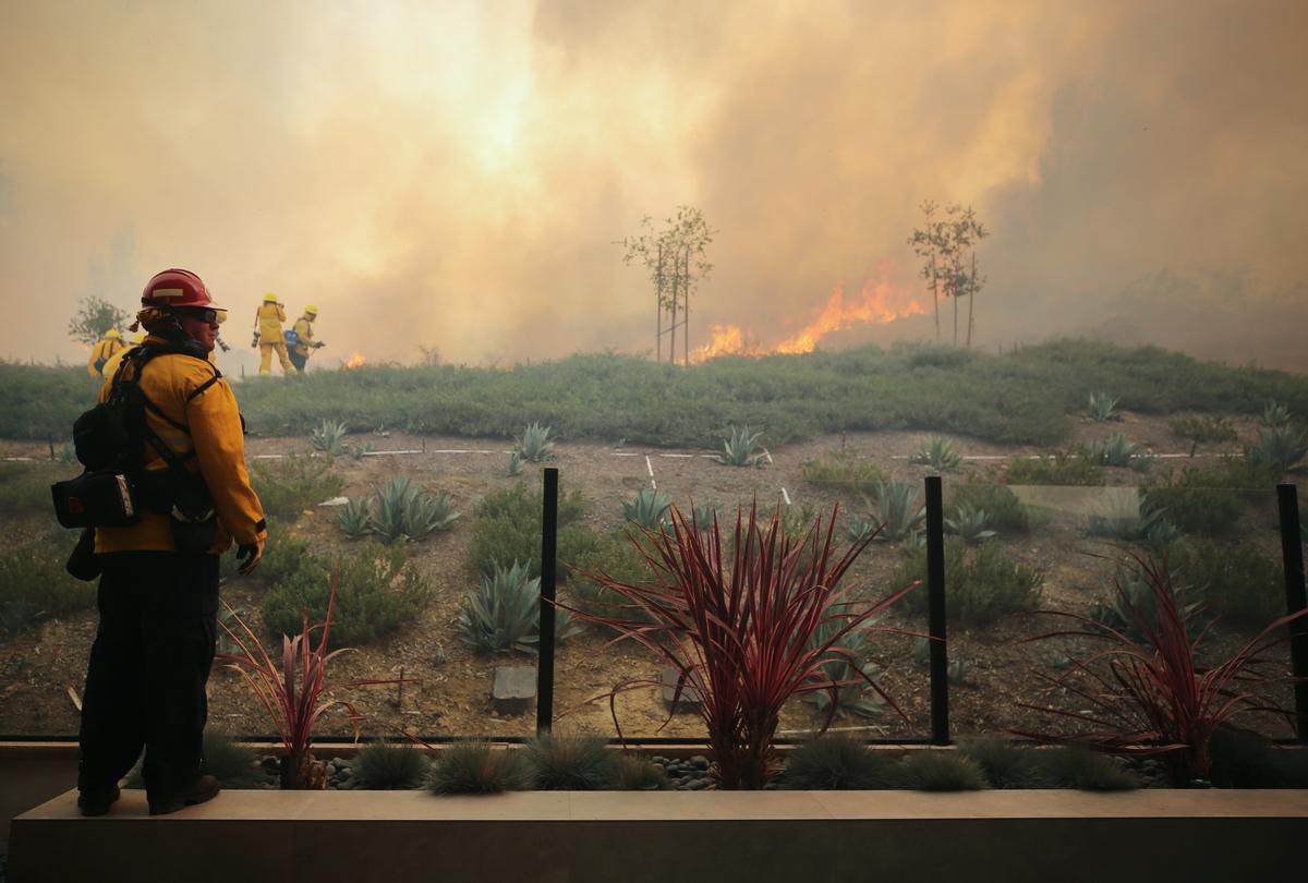 A firefighter works as the Silverado Fire burns toward a home in Orange County on Oct. 26, 2020, in Irvine, Calif. (Mario Tama/Getty Images)