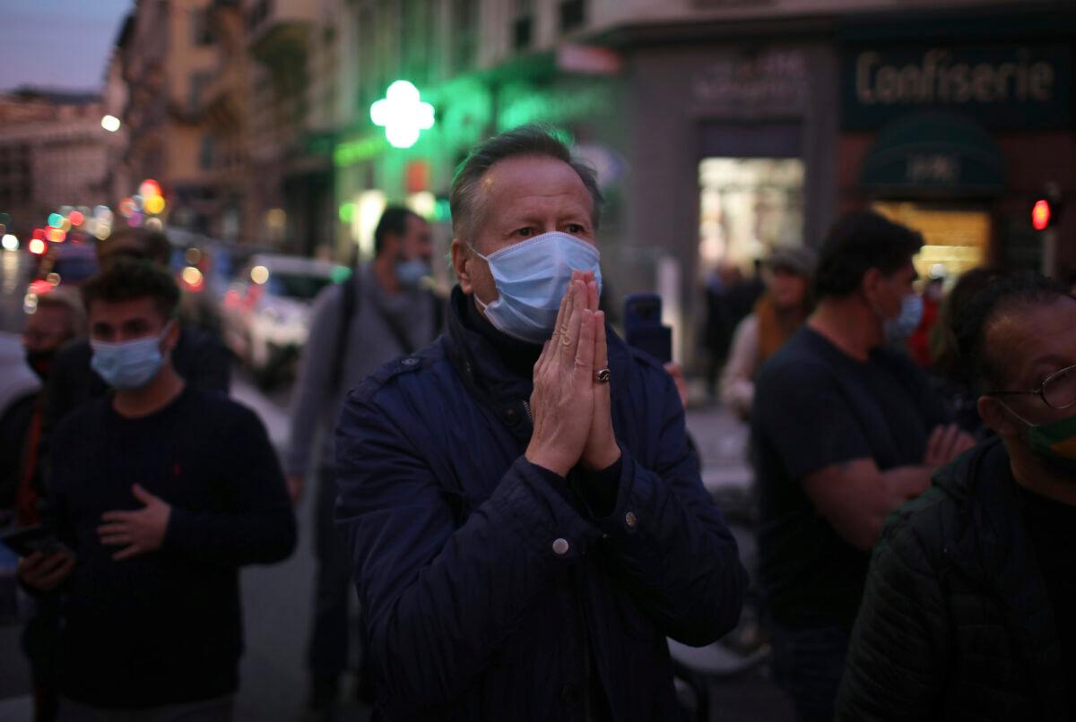 A man prays in the street outside the Notre Dame church after a knife attack took place in Nice, southern France, on Oct. 29, 2020. (Daniel Cole/AP Photo)