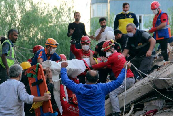 Rescuers carry a man rescued from the debris of his collapsed house, in Izmir, Turkey, on Oct. 30, 2020. (Sadik Cangel/IHA via AP Photo)