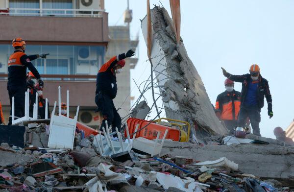 Members of rescue services search for survivors in the debris of a collapsed building in Izmir, Turkey, Oct. 31, 2020. (Darko Bandic/AP Photo)