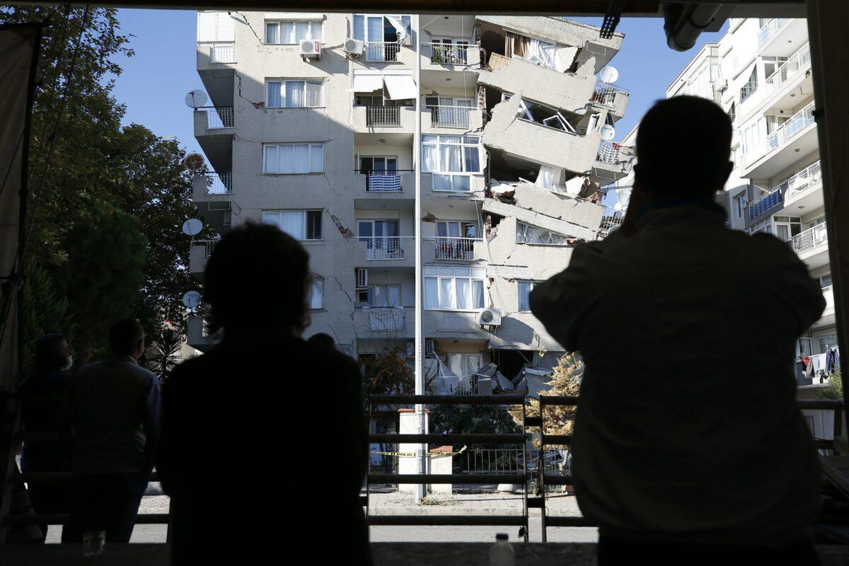  Local residents look at destroyed buildings in Izmir, Turkey, on Oct. 31, 2020. (Emrah Gurel/AP Photo)
