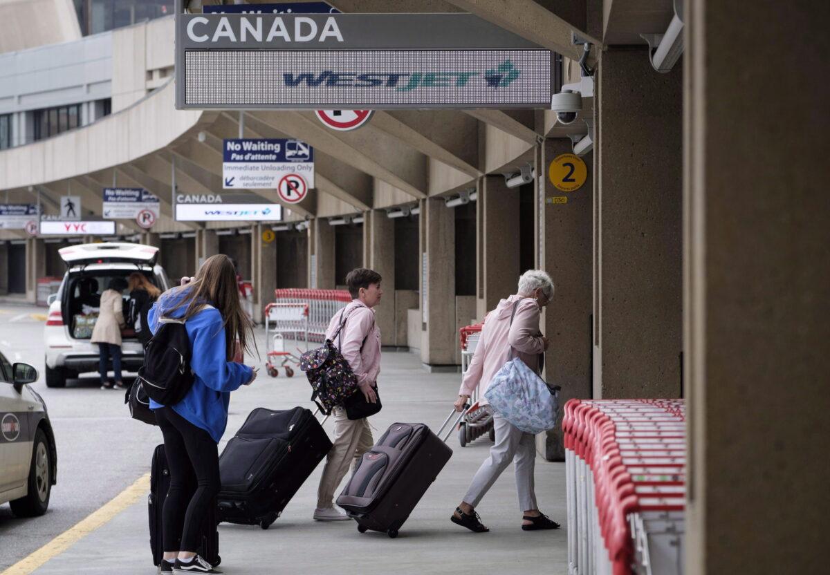 Travelers arrive at the Calgary Airport in Calgary, Canada, on May 10, 2018. (Jeff McIntosh/The Canadian Press)