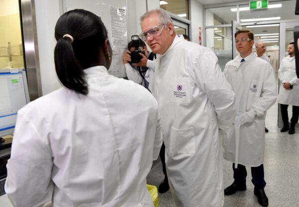 Prime Minister Scott Morrison (centre) is seen during a tour of the University of Queensland Vaccine Lab in Brisbane, Monday, Oct. 12, 2020. (AAP Image/Darren England)