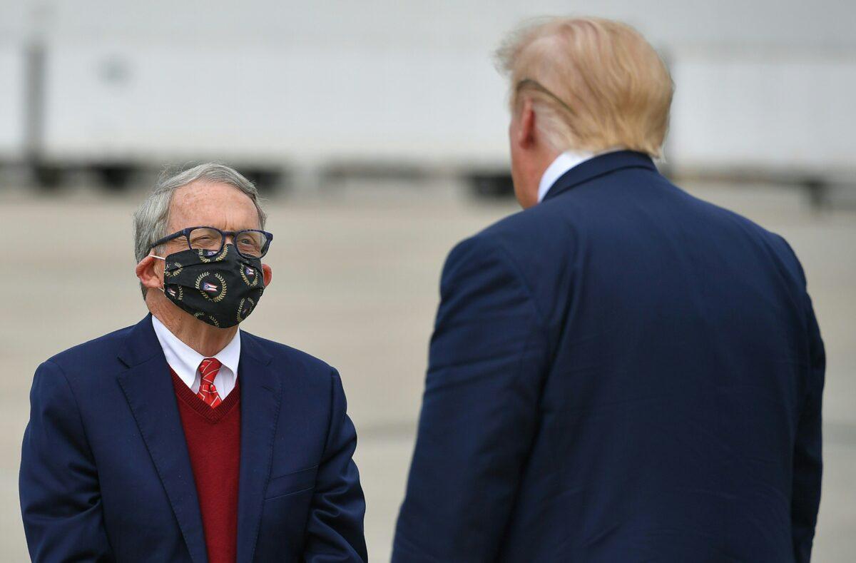 President Donald Trump speaks with Ohio Gov. Mike DeWine upon arrival at Rickenbacker International Airport in Columbus, Ohio, on Oct. 24, 2020. (Mandel Ngan/AFP via Getty Images)