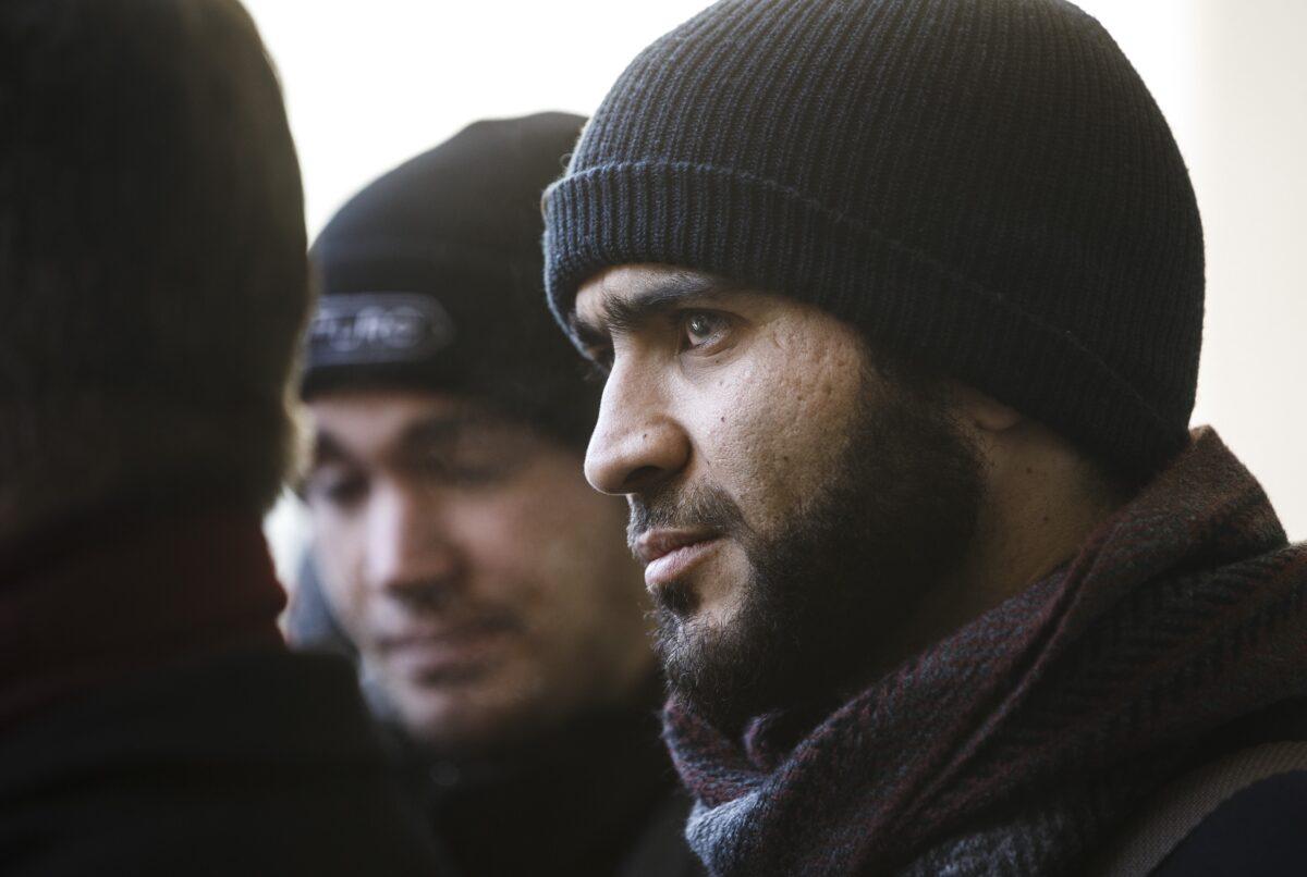 Former Guantanamo Bay prisoner Omar Khadr listens to his lawyer speak to media outside the courthouse in Edmonton, Canada on Feb. 26, 2019. (Jason Franson/The Canadian Press)