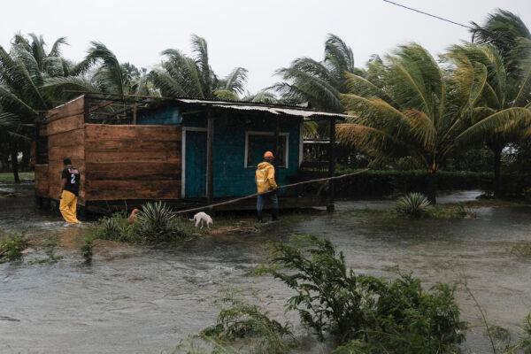 Two men walk next to a flooded house due to the passage of Hurricane Eta in Wawa, Nicaragua, Nov. 3, 2020.(AP Photo/Carlos Herrera)