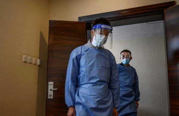 Staff wearing protective attire at a COVID-19 nucleic acid testing location at a hotel near the Great Hall of the People in Beijing, on Oct. 22, 2020. (Kevin Frayer/Getty Images)