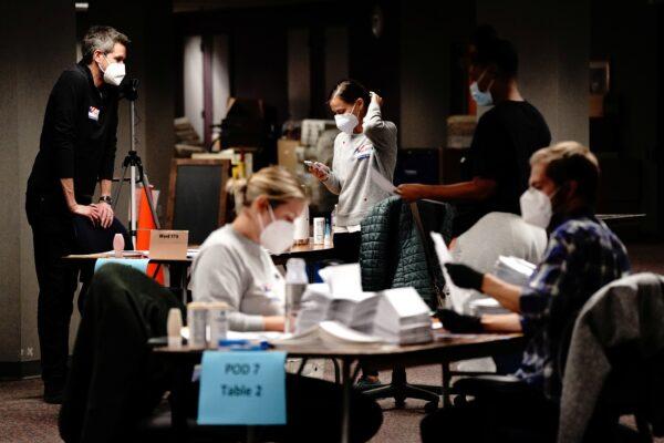 Poll workers process absentee ballots the night of the election at Milwaukee Central Count in Milwaukee on Nov. 3, 2020. (Bing Guan/Reuters)
