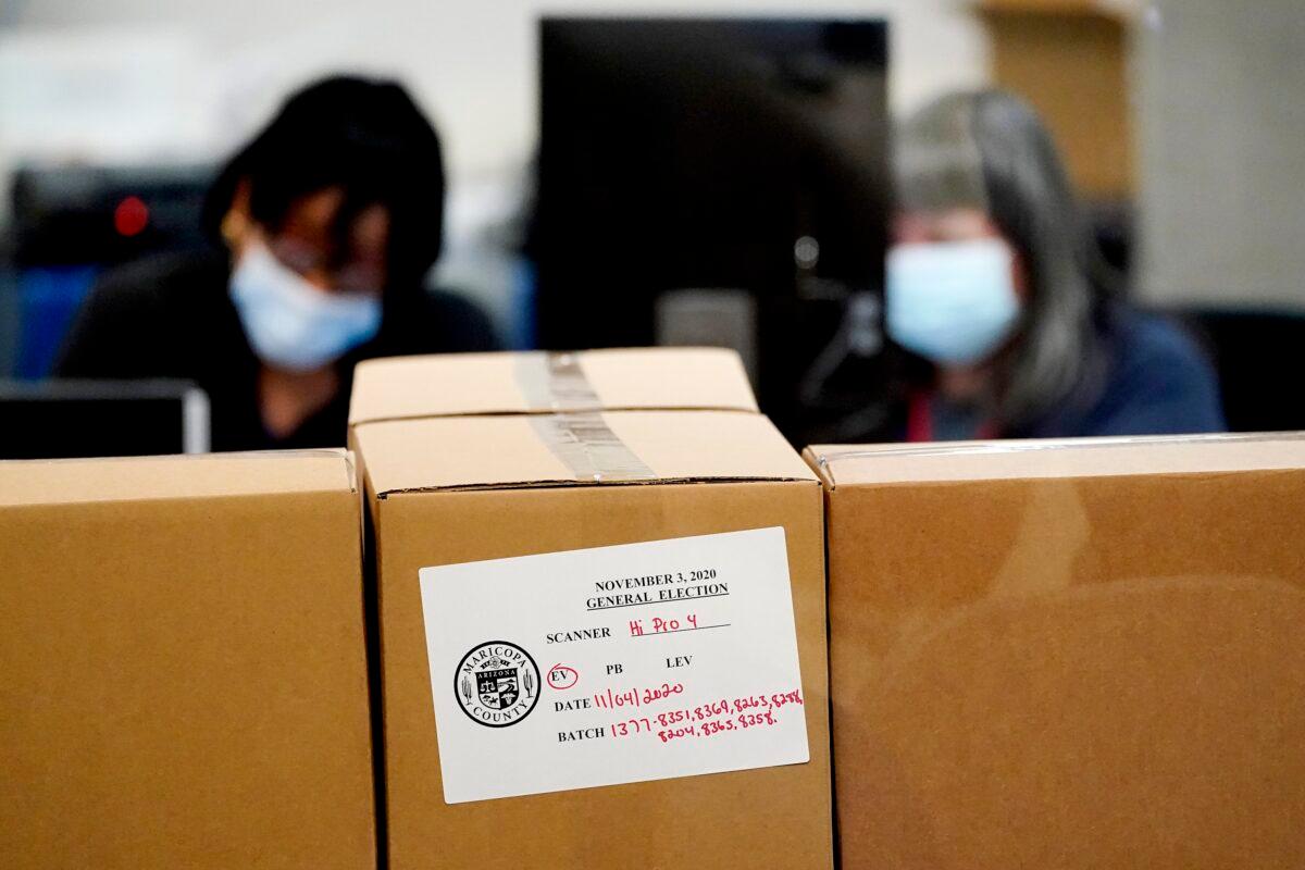 Maricopa County elections officials count ballots behind boxes of counted ballots, Wednesday, Nov. 4, 2020, at the Maricopa County Recorders Office in Phoenix. (Matt York/AP Photo)