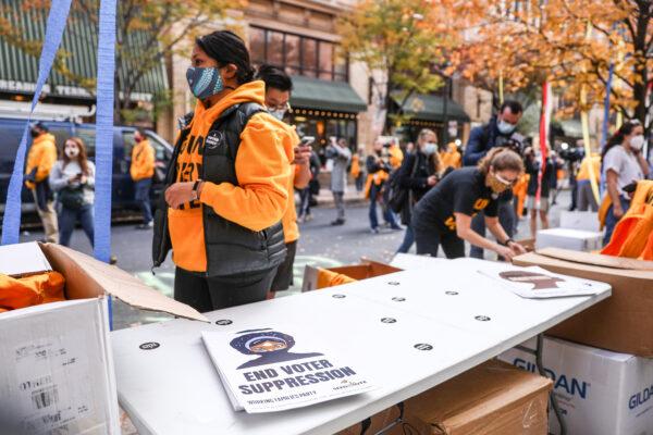 An “End Voter Suppression” poster rests on the Working Families Party table outside the Pennsylvania Convention Center in Philadelphia, Pa., on Nov. 6, 2020. (Charlotte Cuthbertson/The Epoch Times)