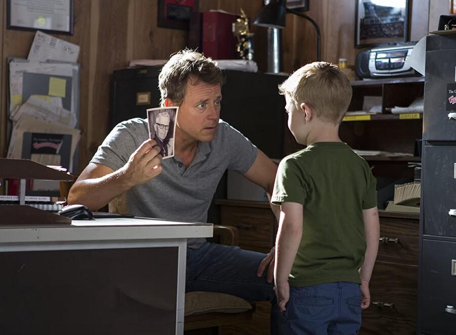 Todd Burpo (Greg Kinnear, L) asks his son, Colton (Connor Corum), if he recognizes someone in a photo taken before Colton was born, in “Heaven Is for Real.” (TriStar Pictures)