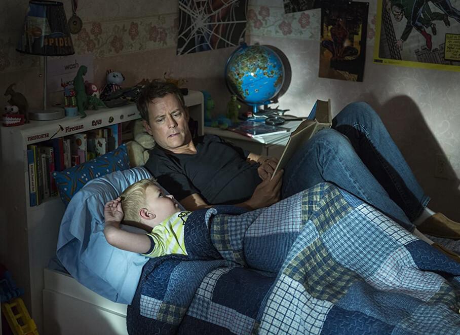 Colton Burpo (Connor Corum, L) and his father, Todd Burpo (Greg Kinnear), have a bedtime story, in “Heaven Is for Real.” (TriStar Pictures)