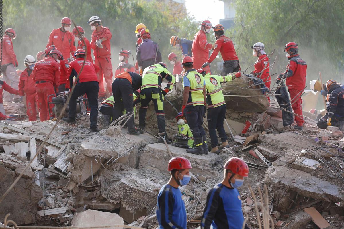 Members of rescue services search for survivors in the debris of a collapsed building in Izmir, Turkey, Monday, Nov. 2, 2020. (Darko Bandic/AP Photo)
