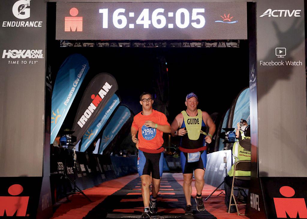 Chris Nikic and his guide, Dan Grieb, cross the finish line of IRONMAN Florida on Nov. 7, 2020, in Panama City Beach, Florida. (Michael Reaves/Getty Images)
