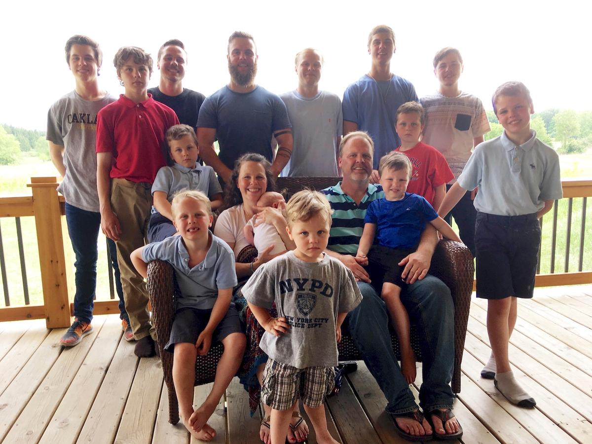 The Schwandt family poses for a photo at their farm in Lakeview, Mich. Standing from left are Tommy, Calvin, Drew, Tyler, Zach, Brandon, Gabe, Vinny, and Wesley. Seated, starting at upper left are Charlie, Luke, mother Kateri holding Finley, father Jay with Tucker and Francisco in the foreground. (Mike Householder/AP Photo)