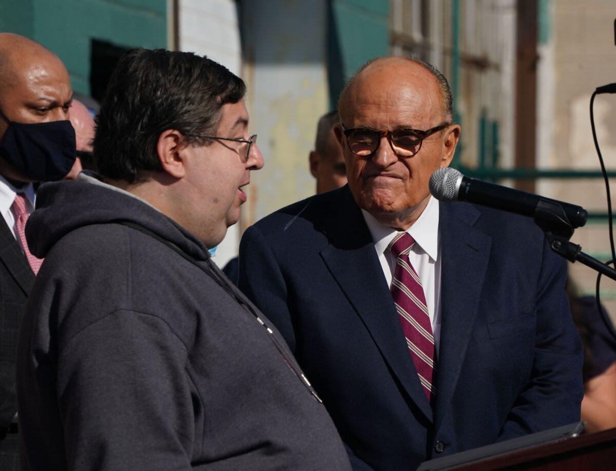 An alleged poll watcher speaks as attorney for the president Rudy Giuliani (C) listens at a news conference in the parking lot of a landscaping company in Philadelphia on Nov. 7, 2020. (Bryan R. Smith/AFP via Getty Images)
