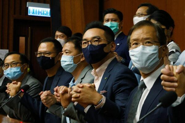 Pan-democratic legislators including Alvin Yeung, Dennis Kwok and Wu Chi-wai join their hands during a news conference as they threat with mass resignations amid reports on Beijing plans to disqualify four opposition lawmakers, in Hong Kong, China, on Nov. 9, 2020. (Tyrone Siu/Reuters)