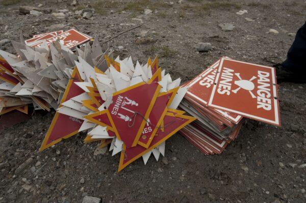 Signs alerting of landmines are removed from a field after recovering the landmark Sappers Hill Corral following a land-mine clearance, on the outskirts of Stanley, Falkland Islands, on March 26, 2012. (Martin Bernetti/AFP via Getty Images)