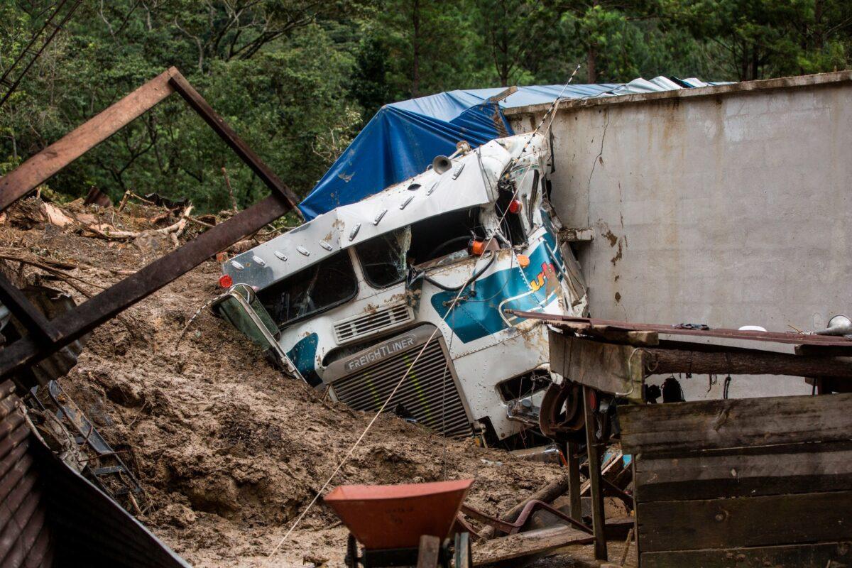 A semi is partially buried in a massive, rain-fueled landslide in the village of Queja, in the aftermath of Tropical Storm Eta, in Guatemala, on Nov. 7, 2020. (Esteban Biba/Pool Photo via AP)