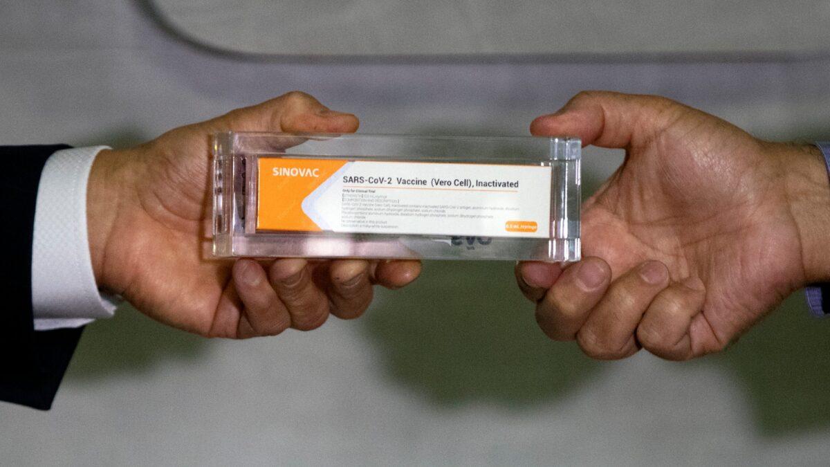 A box of an experimental COVID-19 vaccine is being hold during a press conference in Sao Paulo, Brazil, on Nov. 9, 2020. (Andre Penner/AP Photo)