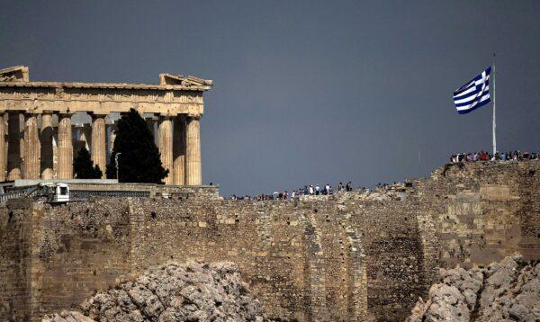 Greek flag flutters in front of the ancient Parthenon temple atop the Acropolis hill archaeological site in Athens, Greece, on June 26, 2015. (Marko Djurica/Reuters)