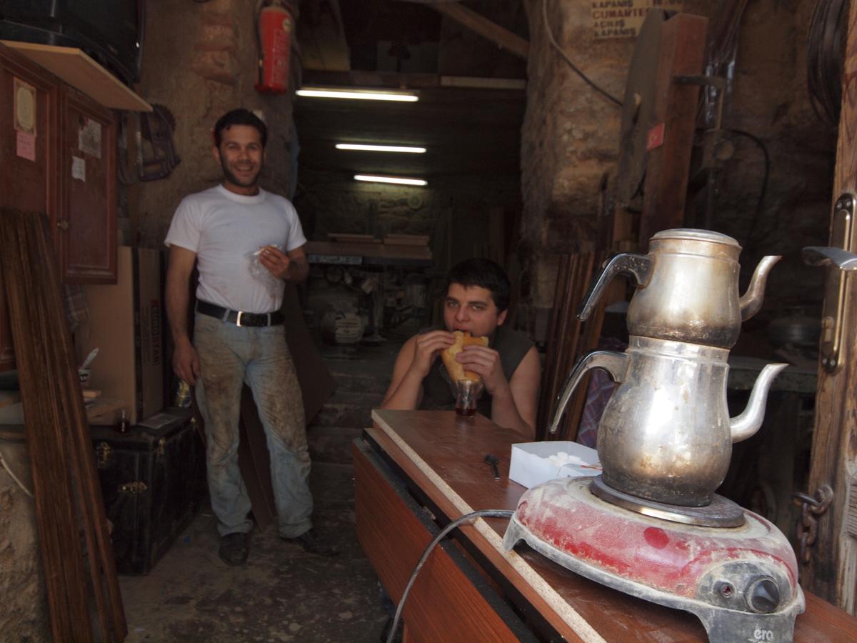 Friendly artisans share tea with a stranger inside their workshop within the ancient city wall. (Kevin Revolinski)