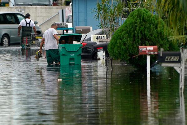 Residents clear debris from a flooded street in the Driftwood Acres Mobile Home Park, in the aftermath of Tropical Storm Eta, in Davie, Fla., on Nov. 10, 2020. (Lynne Sladky/AP Photo)