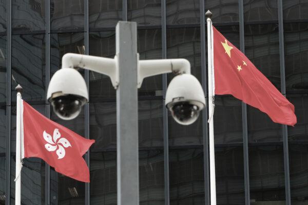Hong Kong and Chinese national flags are flown behind a pair of surveillance cameras outside the Central Government Offices in Hong Kong, July 20, 2020. (Tyrone Siu/Reuters)