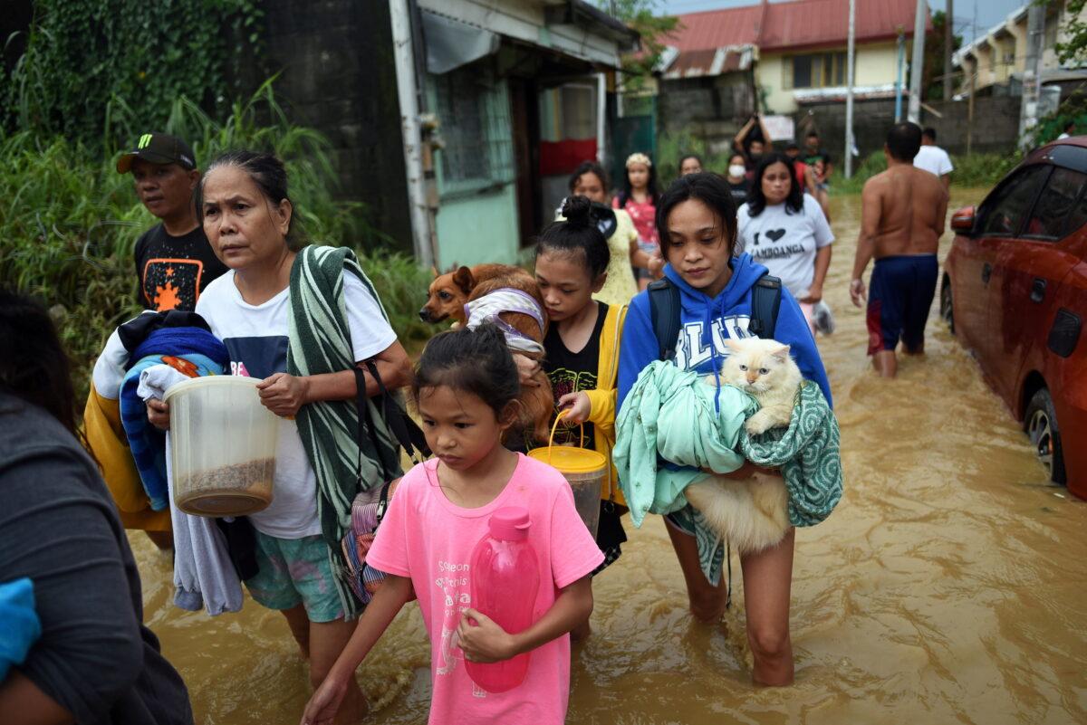 Residents wade through a flooded street following Typhoon Vamco, in Rizal Province, Philippines, Nov. 12, 2020. (Lisa Marie David/Reuters)