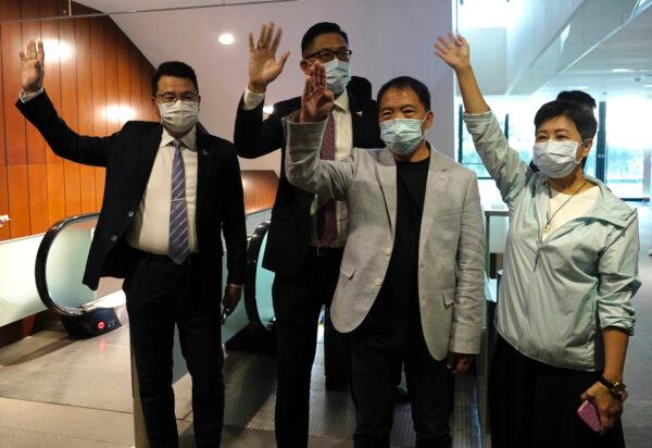 Pro-democracy legislators, Wong Pik Wan (R), Wu Chi Wai (2nd R), Lam Cheuk-ting (2nd L), Yoon Siu Kin (L) wave after handing their resignation letters at Legislative Council in Hong Kong on Nov. 12, 2020. (Vincent Yu/The Associated Press)